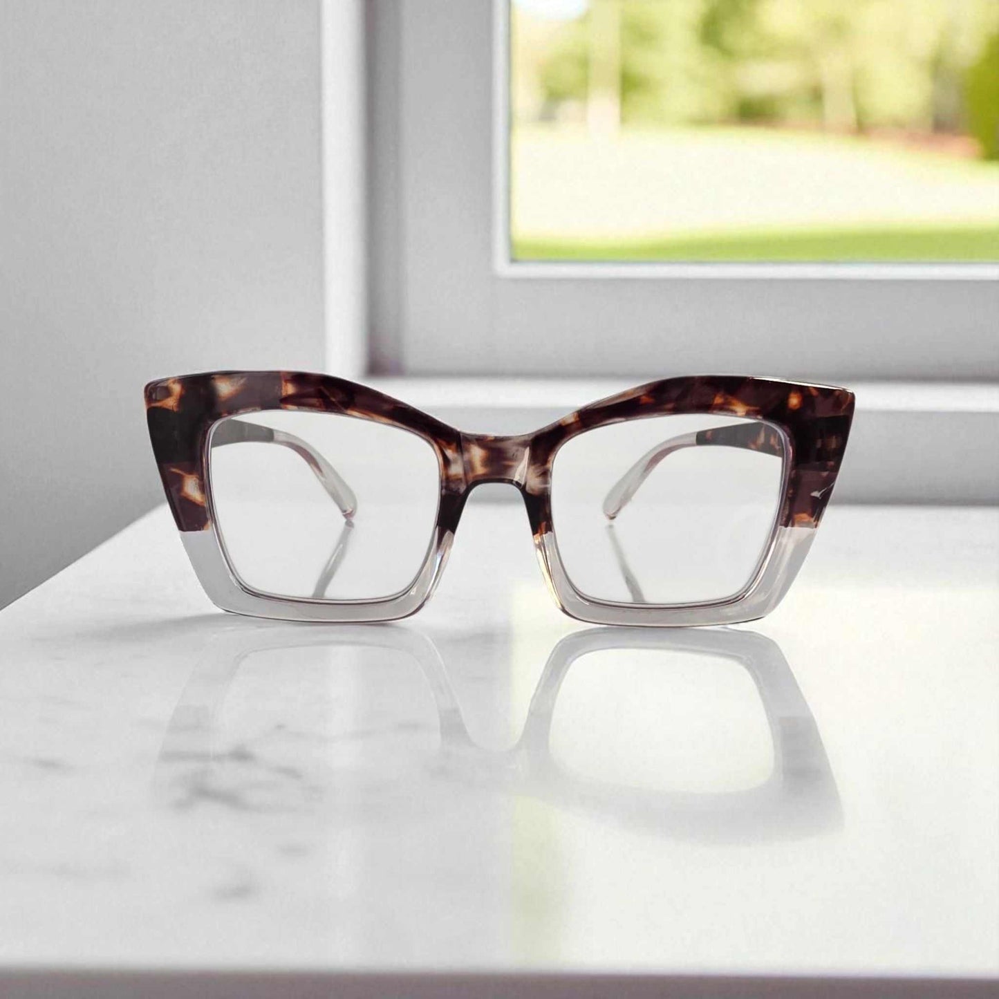 Crystal Clear Tortoiseshell Reading Glasses Crystal clear and tortoiseshell reading glasses with blue light filter on white surface by window