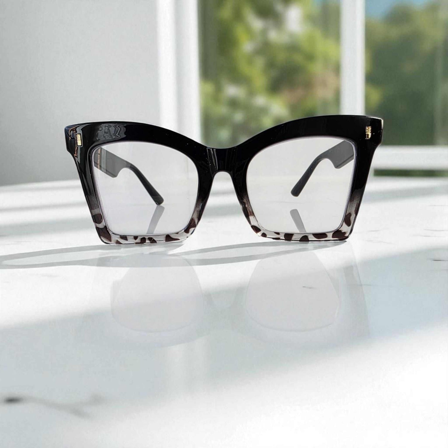 Animal Print Black crystal square reading glasses with blue light filter on white surface.