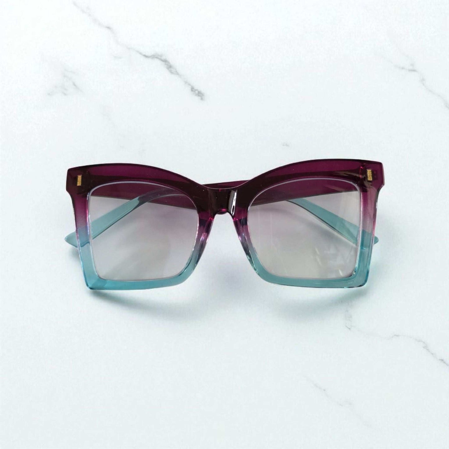 Square reading glasses with gradient purple to blue acetate frames and clear lenses with blue light filter.