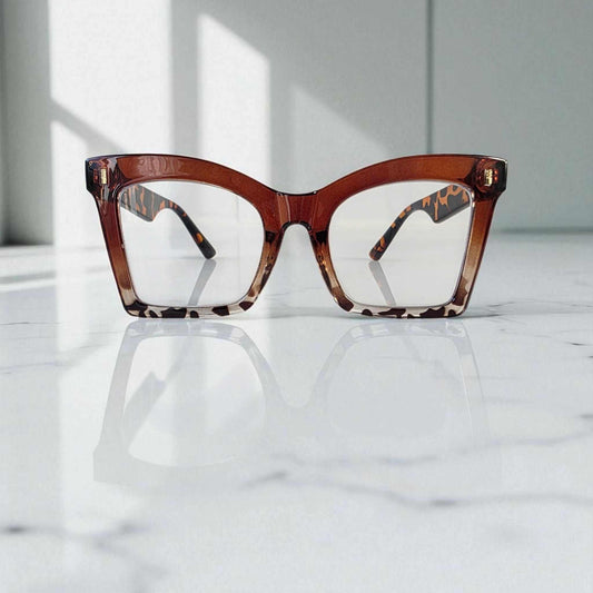 Animal print and tortoiseshell large square reading glasses with blue light filter lenses on marble surface