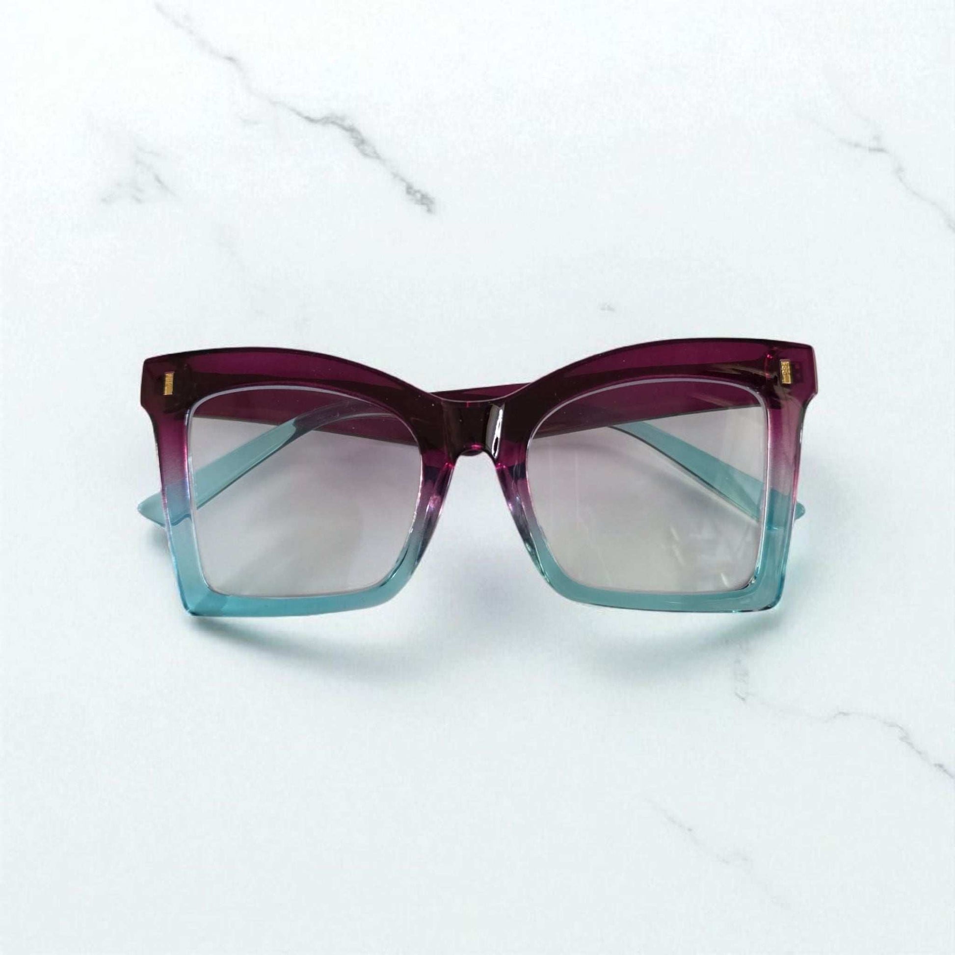 Square reading glasses with gradient purple to blue acetate frames and clear lenses with blue light filter.